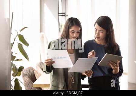 Diverse young project managers discussing marketing research results Stock Photo