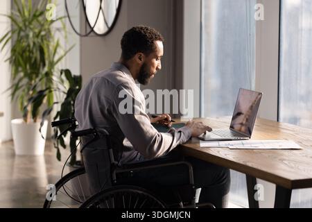 Serious African American businessman with disability using wheelchair Stock Photo