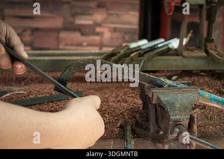 A man's hands sharpening a rubber tapping knife Stock Photo