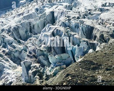 Striking close-up view of the Fee Glacier in Valais, Switzerland, revealing deep crevasses in various shades of ice blue under bright alpine sunlight Stock Photo