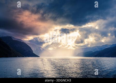 Sunset under a dramatic sky in a Norwegian fjord Stock Photo