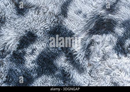 Luxurious soft gray and black faux fur texture closeup showing shaggy synthetic hair pattern with fluffy warm feeling suitable for cozy winter fashion Stock Photo