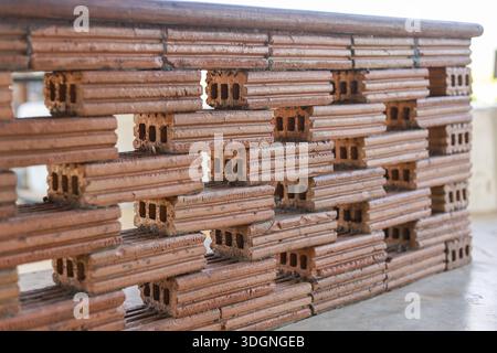 Unique brown brick wall construction featuring hollow rectangular pattern and strong solid structure with textured surface outdoors conveying stabilit Stock Photo
