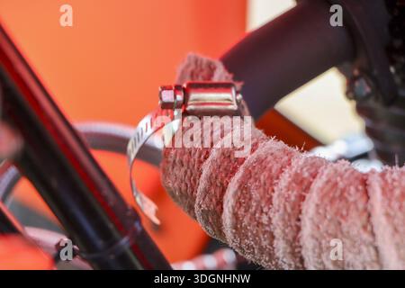 Detailed close up shot metal hose clamp securing textured rubber pipe showing secure connection and mechanical strength with focused orange background Stock Photo