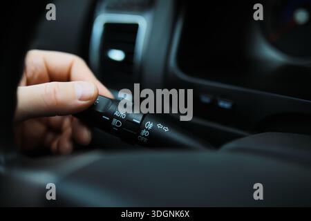 The process of choosing climate control in the car. Man regulating temperature on car air condition. Modern car interior Stock Photo