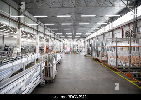 Production area for metal-plastic or PVC windows, commonly known as vinyl window, featuring organized rows of metal profiles and frames, specialized e Stock Photo
