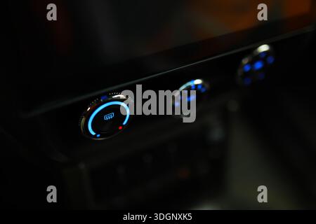 The process of choosing climate control in the car. Man regulating temperature on car air condition. Modern car interior Stock Photo