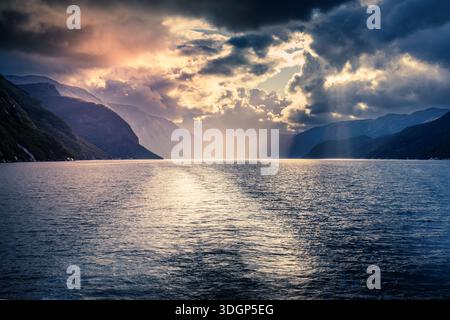 Sunset under a dramatic sky in a Norwegian fjord Stock Photo