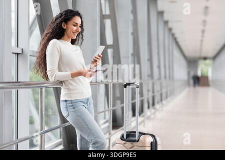 Portrait Of Beautiful Young Woman Using Smartphone While Waiting At Airport Stock Photo