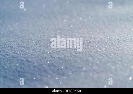 Granular snow surface detail in macro, evenly distributed crystals and faint blue cast revealing measurable grain patterns for scientific, educational Stock Photo