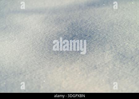 Sunlit snow depression with subtle sparkle, rounded hollow in fresh powder with delicate shadowing, sparkling crystals and warm contrast, fine grain d Stock Photo