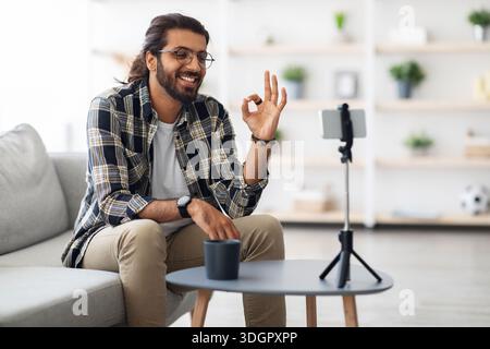 Cheerful indian guy with glasses blogger streaming from home Stock Photo