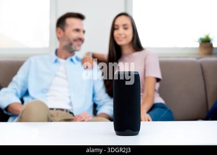 Couple using smart speaker, smart home system appliance, modern assistant || Model released Stock Photo