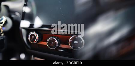 The process of choosing climate control in the car. Man regulating temperature on car air condition. Modern car interior Stock Photo