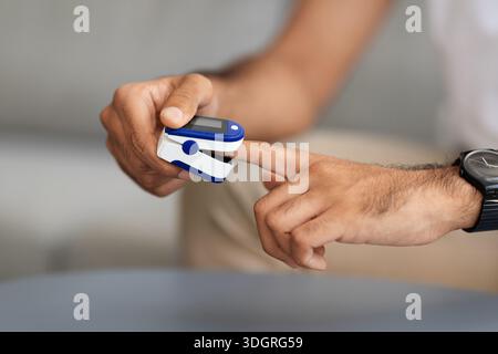 Unrecognizable man using pulse oximeter, closeup photo Stock Photo