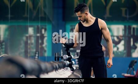 Bodybuilding Concept. Muscular Young Arab Man Training With Dumbbells At Gym Stock Photo