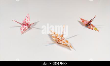 Origami paper cranes isolated on white background. Japanese traditional culture. Paper sculpture through folding and relaxing techniques. Origami art. Stock Photo