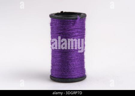 Spool purple thread on white background, closeup Stock Photo