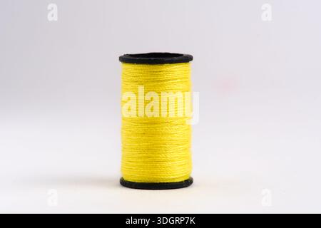 Spool of yellow thread isolated on white background Stock Photo