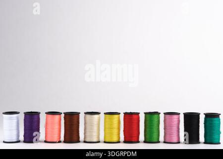 Spools of multicolored sewing threads on white background Stock Photo
