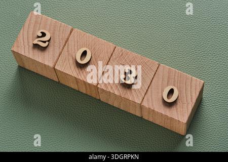 Wooden cubes with year 2030 on green background, business concept Stock Photo