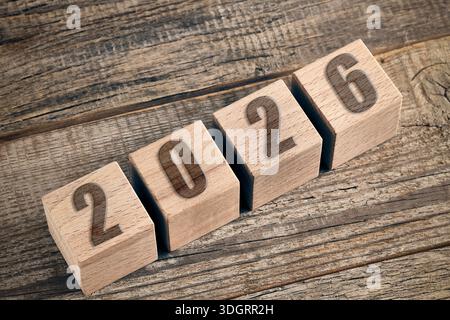 Wooden cubes with year 2026 on wooden background. New year concept Stock Photo