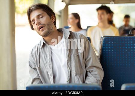 Portrait of tired guy sleeping in bus Stock Photo