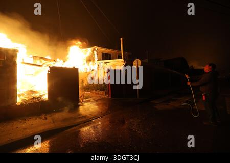 Concepcion, Chile. 28th Jan, 2026. Concepción, Chile - January 18, 2026: Residents try to extinguish the fire using their own resources. A tragic preliminary toll confirms one death and 253 homes destroyed following uncontrolled wildfires in the commune. Driven by strong winds overnight, the flames rapidly reached urban sectors, also affecting the neighboring towns of Penco and Lirquén. Emergency crews are struggling to contain the disaster in the Biobío region as the fire consumes residential areas. (Photo: Carlos Acuña/ATON/UNAR AGENCY) Credit: Sipa USA/Alamy Live News Stock Photo