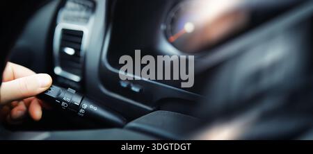 The process of choosing climate control in the car. Man regulating temperature on car air condition. Modern car interior Stock Photo