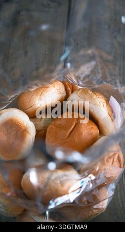 Soft bread rolls in a plastic bag, freshly baked with a golden brown surface, simple everyday bakery food captured in warm natural light Stock Photo