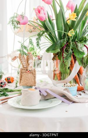 Easter table close up detail. Easter bunny egg cosy and folded napkin decorations for festive Sunday breakfast Stock Photo