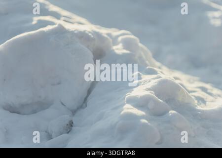 Snowdrift formation in close view with rounded shapes and layered texture, minimal winter scene highlighting cold surface and natural light Stock Photo