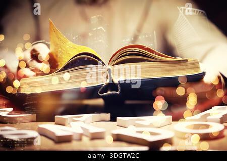 Close up of an unrecognizable man holding a book standing against a morning city panorama. Mock up, toned image, double exposure Stock Photo