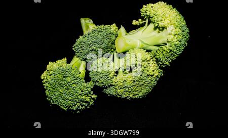 Fresh green broccoli florets rich in vitamins and fiber isolated on a dark background. Stock Photo