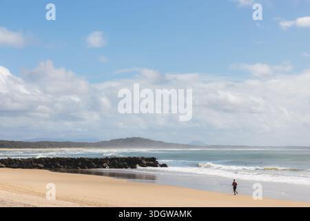 Silhouette of a man jogging a long the sandy shore of Noosa Beach in Noosa Heads, Sunshine Coast, Queensland, Australia. Stock Photo