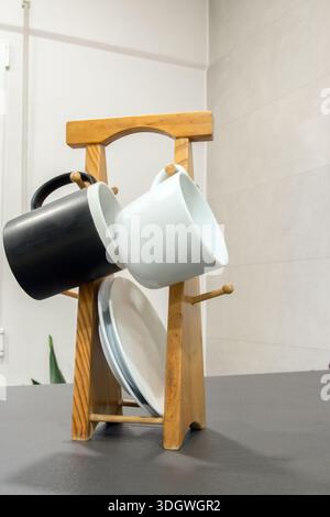 Wooden cup holder with black and white cups and plates Stock Photo