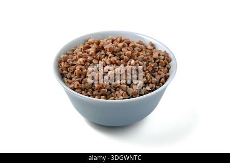 Boiled buckwheat in a blue bowl isolated on white background. Stock Photo