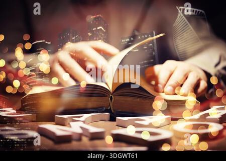 Close up of an unrecognizable man holding a book standing against a morning city panorama. Mock up, toned image, double exposure Stock Photo