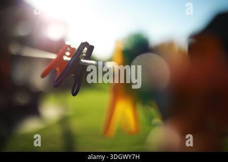 old pegs on a rope. One old retro clothespin wooden on a linen rope. Work on the house, washing, drying linen. Old Dirty Blue and Pink clothes peg on Stock Photo