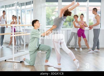 Ballet studio - teenagers girls and boys learn ballet movements in pairs Stock Photo