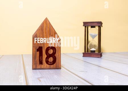 A wooden calendar displaying the date February 18. This image symbolizes time management and date tracking, perfect for personal or professional use. Stock Photo