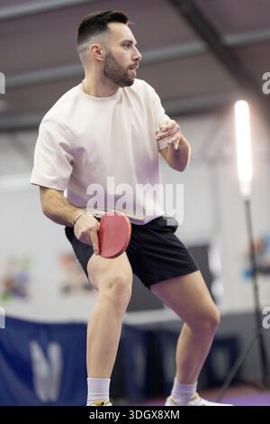 Athlete concentrating, holding table tennis paddle, ready to play Stock Photo