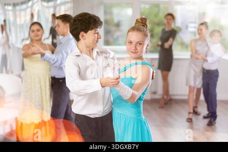 Adolescent ballroom dancers practicing elegant dance moves in pairs Stock Photo