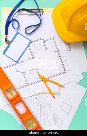 Architect's supplies with house plans on green background Stock Photo