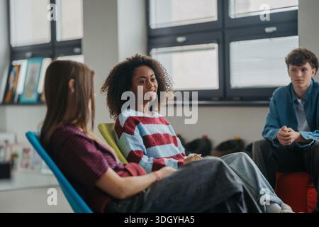 Classmates relaxing and talking in high school lounge. Stock Photo