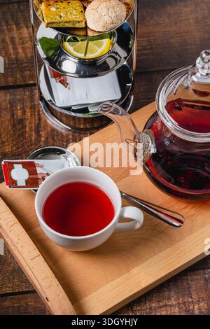 Glass teapot with hot black tea served on wooden tray Stock Photo