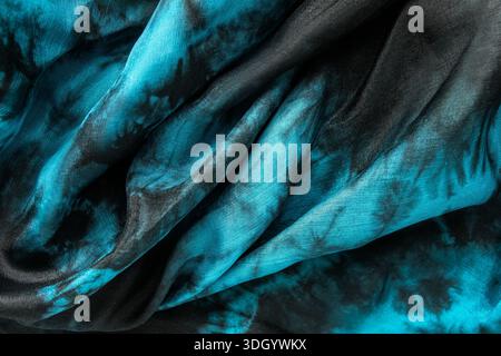 Draped blue and black satin fabric as a background closeup Stock Photo