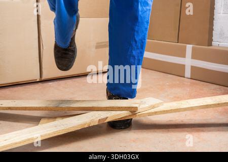 Close up of a construction worker stumbling with a cord in a warehouse Stock Photo