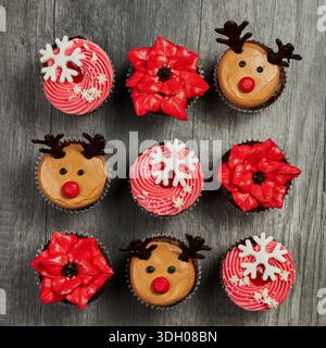 Christmas cupcakes with reindeer and red flowers Stock Photo