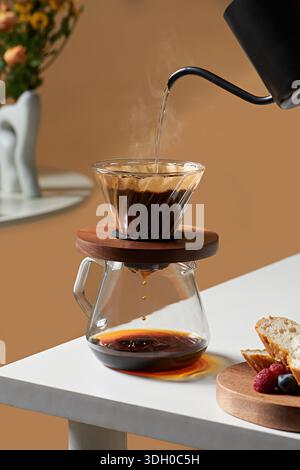Pouring hot water into glass dripper for professional manual pour over coffee brewing Stock Photo